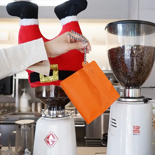 Tenir à la main des sacs de café de 150g avec porte-bourse dans un café