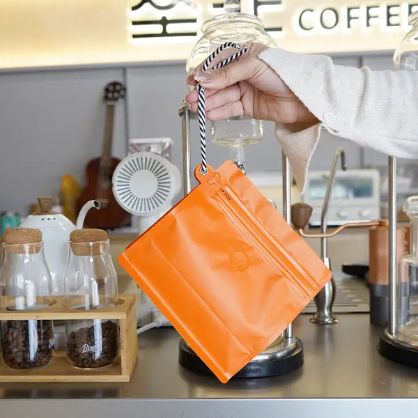 Tenir la main des sacs de café en stock de 250g avec un cordon dans un café