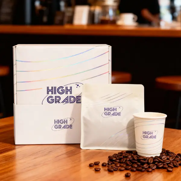 Boîte à café premium personnalisée présentée avec un sachet et une tasse dans un environnement café