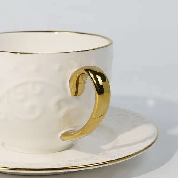 Détail du manche en or d’une tasse en céramique embossée sur mesure