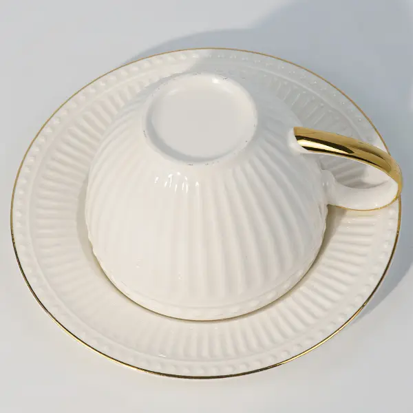 Vue du bas d’une tasse en céramique embossée avec soucoupe assortie