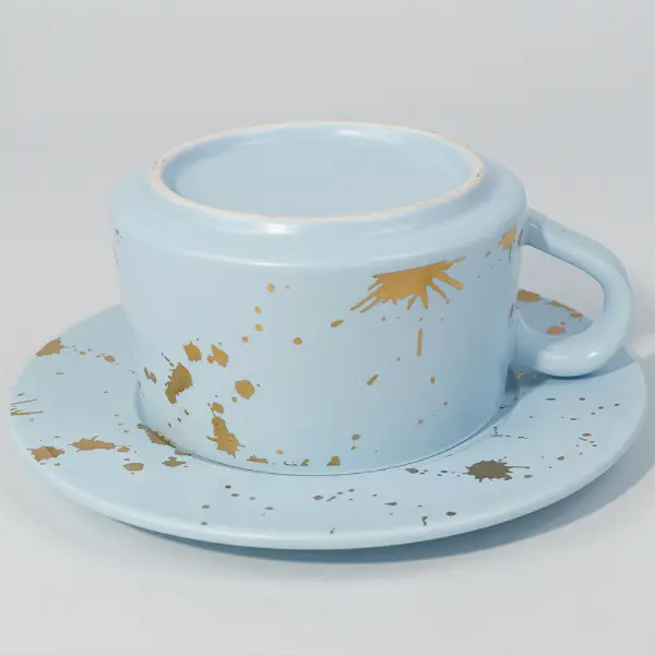 Vue du bas d’une tasse à café en céramique en feuille d’or montrant une finition lisse de l’émail