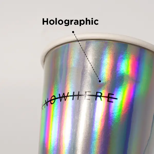 Gros plan de la bouche de la tasse holographique en papier avec rebord roulé