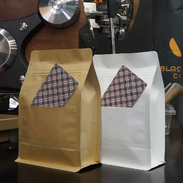 Sacs de café en papier Kraft avec fente en carton exposés dans un environnement de café