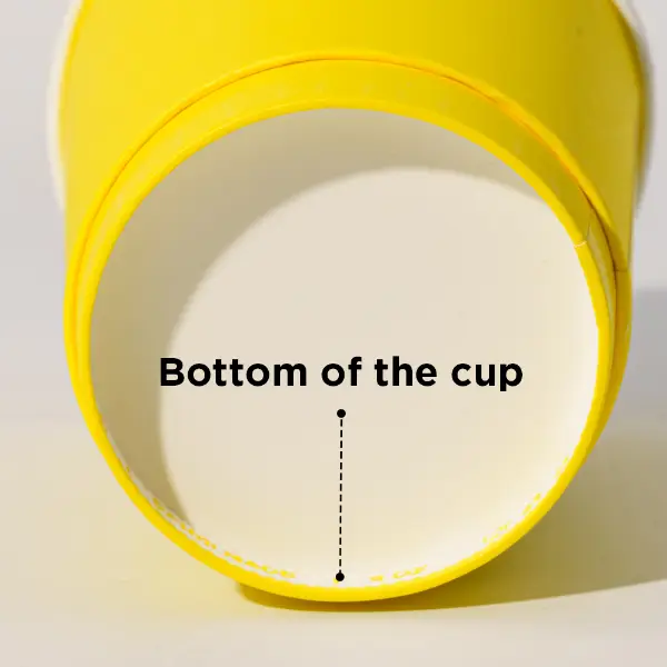 Gros plan sur la structure du bas d’un gobelet en carton jaune montrant le motif du fond du gobelet